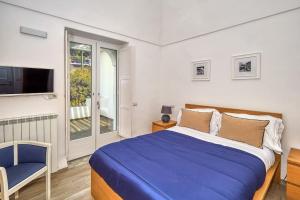 ein Schlafzimmer mit einem Bett, einem Fernseher und einem Stuhl in der Unterkunft DENTECALA 4 in Capri