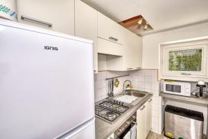 eine Küche mit weißen Schränken und einem Herd mit Backofen in der Unterkunft DENTECALA 4 in Capri