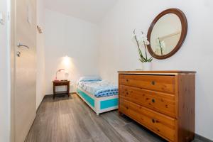una camera da letto con cassettiera e specchio di B&B Oasi a Finale Ligure