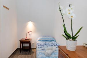 una camera con un letto e un tavolo con un vaso di fiori di B&B Oasi a Finale Ligure
