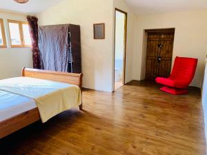 sypialnia z łóżkiem i czerwonym krzesłem w obiekcie Gîte Bidallon w mieście Saint-Michel-Saint-Jaymes