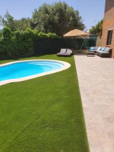 einen Hinterhof mit Pool und grünem Gras in der Unterkunft Vivalavida playa 1km in Lloret de Mar