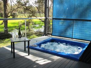a jacuzzi tub on a deck with a table at Hidden Grove Retreat in Boyup Brook