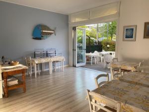 salon ze stołami i krzesłami oraz patio w obiekcie Hotel ai Fiori w Grado