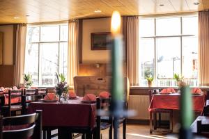 uma sala de jantar com mesas, cadeiras e janelas em Hotel Viby Kro em Viby