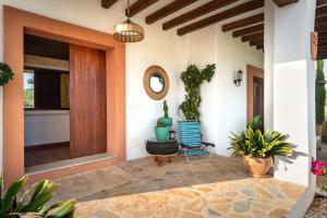 a house with a porch with a chair and a mirror at Villa Cana Clara in Sant Carles de Peralta