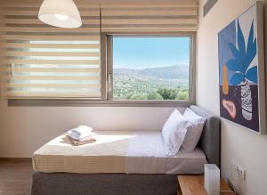 a bedroom with a bed and a large window at Utopia Luxury Villas in Gouves +209 photos