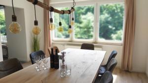 a dining room table with wine bottles and glasses at Villa Bad Bertrich in Bad Bertrich