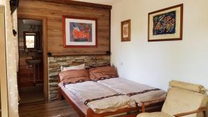a bedroom with a bed and a stone wall at Restaurant and Apartments - T'ga za Jug Lazaropole in Lazaropole