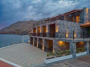 a building on the side of a body of water at XENIA HOTEL in Sfakia