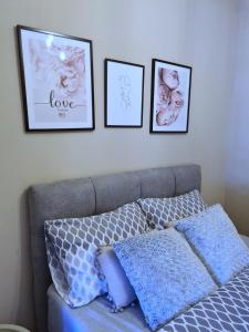 una camera da letto con un divano e tre immagini sul muro di Apartment Blue Lagoon a Mostar