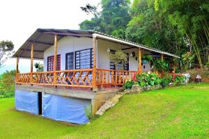 a small house with a wooden deck in a yard at Saranna Cabaña in San Agustín