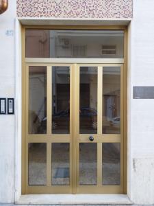 Scirocco Guest House في برينديسي: باب لمبنى به نوافذ زجاجية