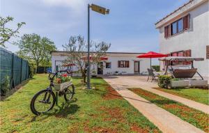rower zaparkowany w trawie obok budynku w obiekcie Cozy Apartment In Fazana With Wifi w Fažanie +15 zdjęć