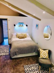 a bedroom with a large bed and a mirror at Seagull’s Cry in Camborne