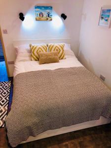 a bed with white sheets and pillows in a room at Seagull’s Cry in Camborne