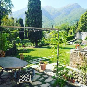 a patio with a table and a view of a garden at Casa Lumaca in Tremezzo