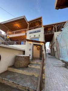 een gebouw met een trap naar een gebouw met een balkon bij ''NAVO'' Guest House in Bukhara