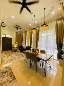 a living room with a dining table and a ceiling fan at THE PINE HOUSE in Kuala Berang