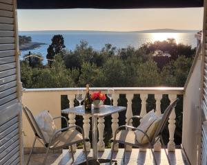 einen Tisch und Stühle auf einem Balkon mit Meerblick in der Unterkunft Belvedere in Silba