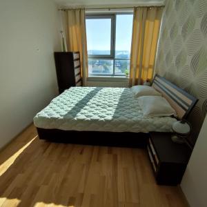 a bedroom with a bed with a large window at Sunset Terrace Apartment in Klaipėda