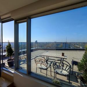 balkon ze stołem i krzesłami w obiekcie Sunset Terrace Apartment w Kłajpedzie