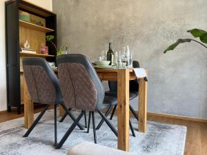 a dining room table with two chairs and a bottle of wine at Designapartment Blue Sky -55m2-free parking & wifi in Graz