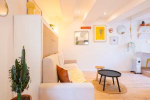 a living room with a couch and a table at Appartement cocooning proche mer in Carqueiranne