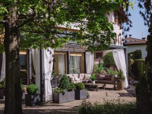 a patio with couches and plants in front of a building at Relais Villa Quercia in Tassullo