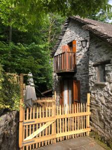 una valla de madera frente a una casa de piedra en Cà dal Bosc e Cà sgrüscia, en Giumaglio