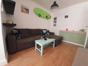 a living room with a couch and a surfboard on the wall at Santos LODGE surf - 5 minutes walking to Praia da Rocha in Portimão