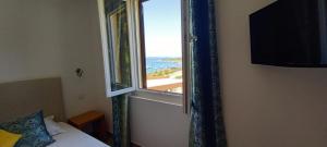 a bedroom with a window with a view of the ocean at Hôtel du Golfe in Bonifacio