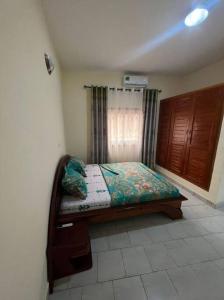 - un petit lit dans une chambre avec fenêtre dans l'établissement Résidence Allégra, à Yaoundé