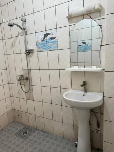 a bathroom with a sink and a shower with a mirror at Résidence Allégra in Yaoundé