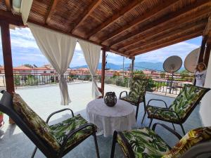 a porch with a table and chairs and a view of a patio at Elvetos Makedonia in Nea Vrasna