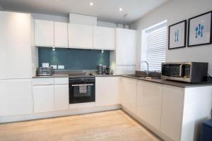 a kitchen with white cabinets and a microwave at Orchard Point in Southampton
