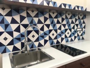 a kitchen with a sink and blue and white tiles at CasaMare - Luxury Apartment and Pool - Sorrento in Sorrento