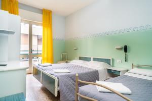 um quarto de hotel com duas camas e uma cozinha em Hotel Viscount em Riccione