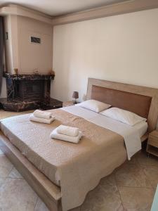 a bedroom with a large bed with two towels on it at Sia's house near to airport in Artemida