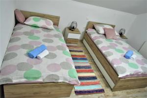 two twin beds in a room with at Guest House Tonka in Otočac