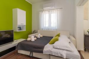 a bedroom with a large bed with green walls at Apartment Roko in Trogir