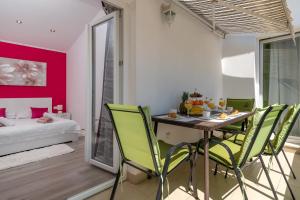 a dining room with a table and green chairs at Apartment Roko in Trogir