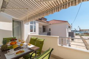 a balcony with a table with fruit on it at Apartment Roko in Trogir