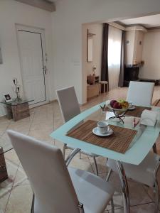 uma mesa e cadeiras numa sala de estar em Sia's house near to airport em Artemida