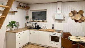 cocina con armarios blancos y mesa en Sepa Puhkekeskus, en Käina