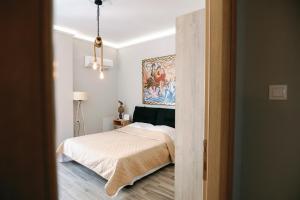 een slaapkamer met een bed en een schilderij aan de muur bij ORFEAS suite AXD in Alexandroupoli