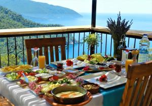 una mesa con platos de comida en la parte superior de un balcón en Kabak Misafir Evi, en Muğla