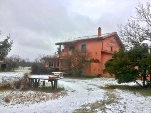 una casa con una mesa delante de ella en la nieve en La casa di Francesco Incantevole casale di campagna with pool piscina, en Soriano nel Cimino