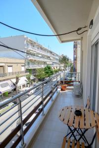 een balkon met een tafel en uitzicht op een straat bij ORFEAS suite AXD in Alexandroupoli