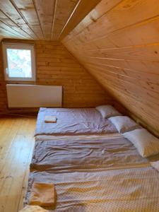 a bed in a wooden cabin with a window at Casa Gyerő in Sovata +24 photos